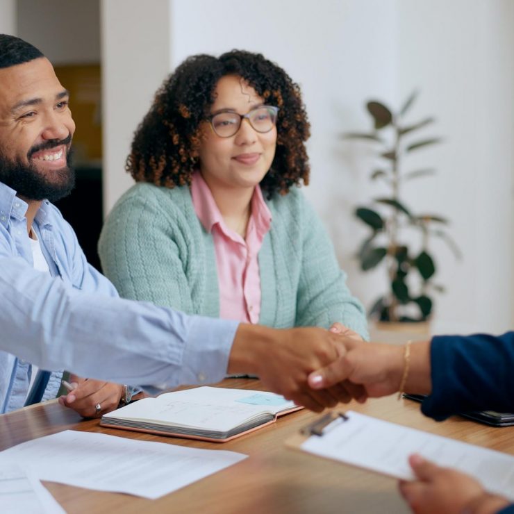 Couple, handshake and lawyer with documents for real estate, property investment or loan application with smile. People, man and woman with advisor, paperwork and shaking hands for legal deal or will