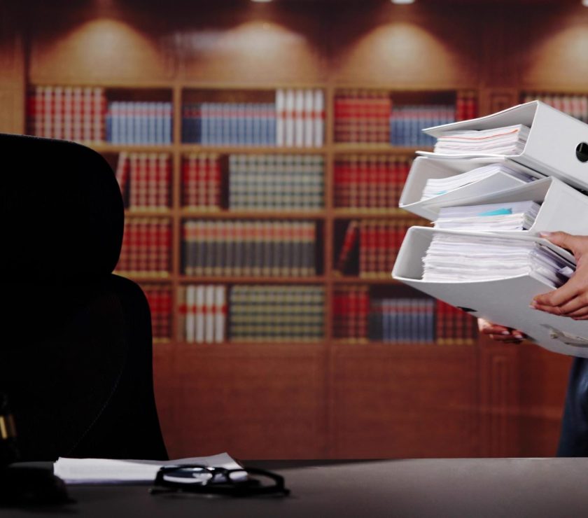 Midsection Of Female Lawyer Carrying Stack Of Ring Binders