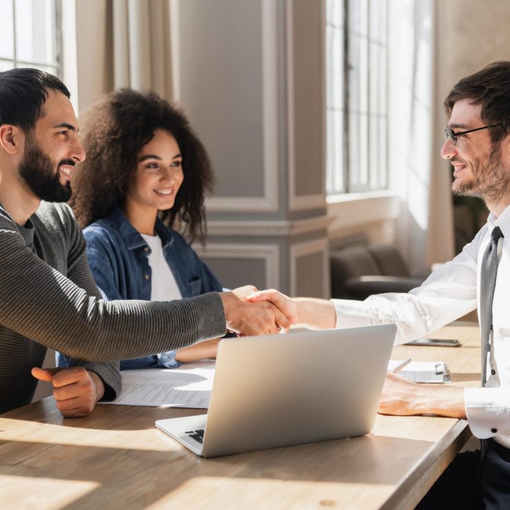 Couple handshake mortgage officer worker, accept bank loan terms and rates feel satisfied.
