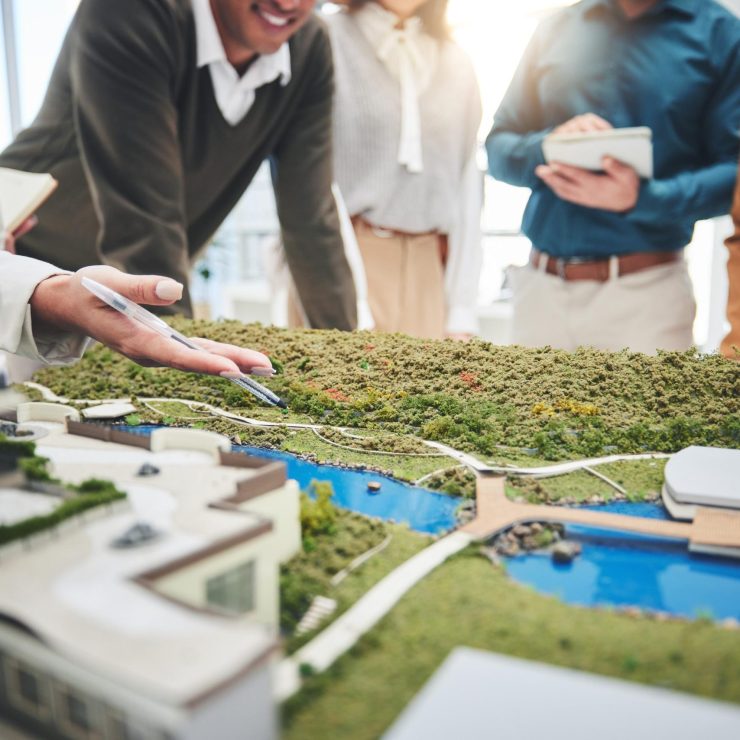 Creative people, hands and real estate with 3d model of building design, architecture or property at office. Closeup of group architect team in meeting, project planning or floor layout at workplace