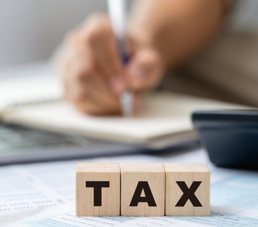 Man is calculating annual tax, monthly expenses with calculator and filling form of Individual Income Tax Return. Season to pay Tax and Budget planning concept.