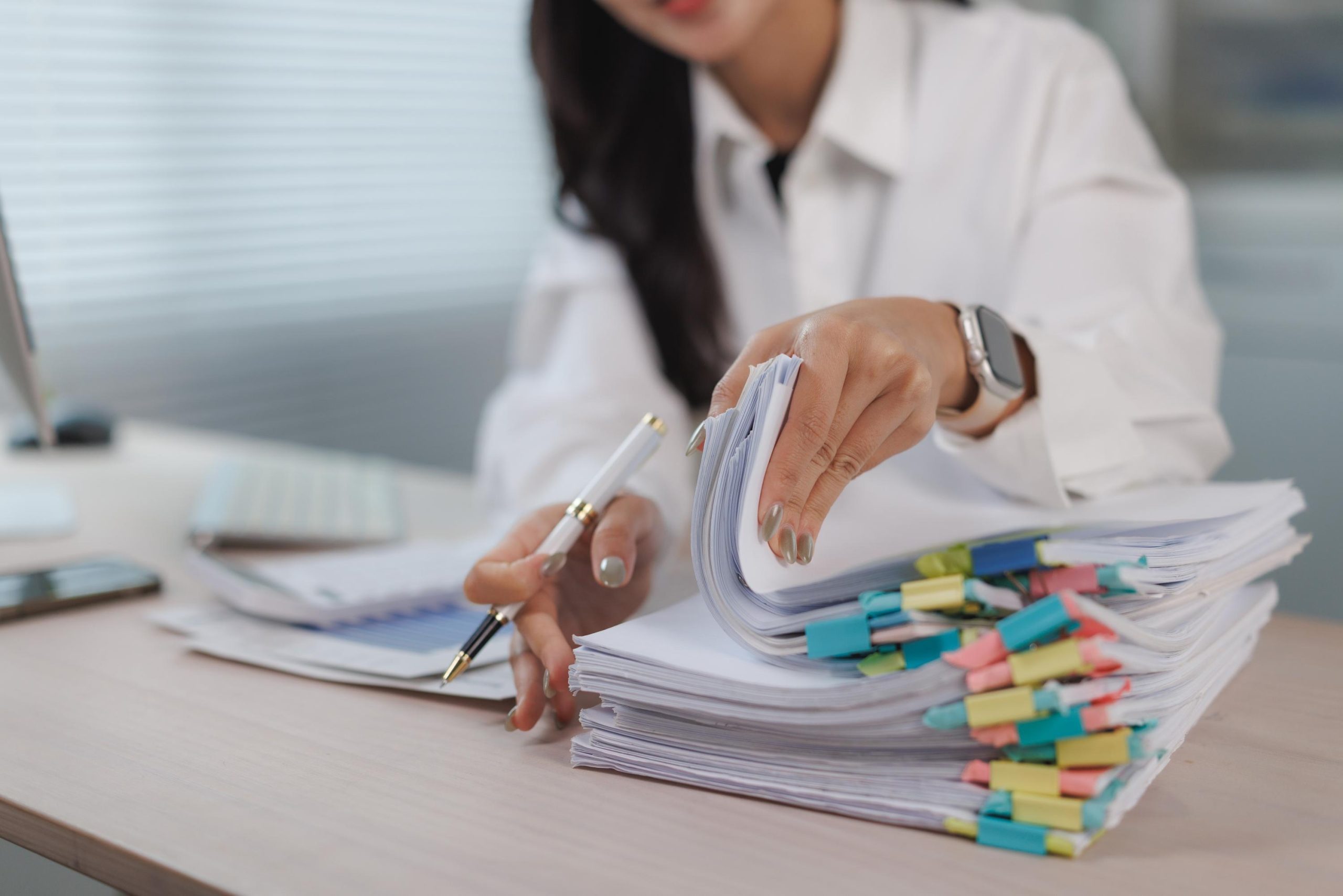 Woman organizing business documents with colorful clips